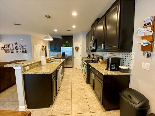 kitchen featuring pendant lighting, backsplash, stainless steel appliances, and sink