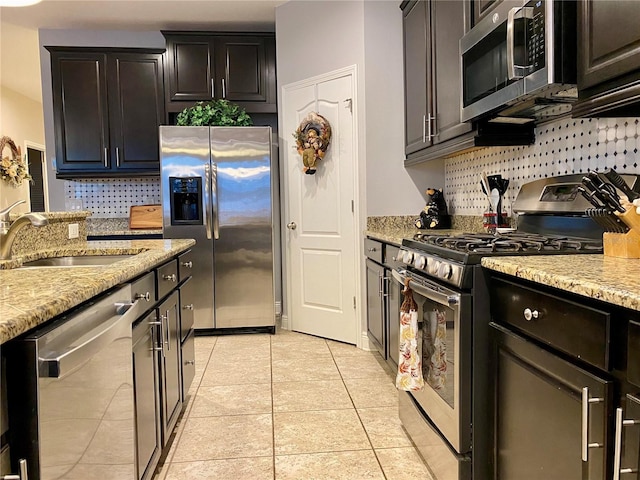 kitchen with light stone countertops, sink, and stainless steel appliances