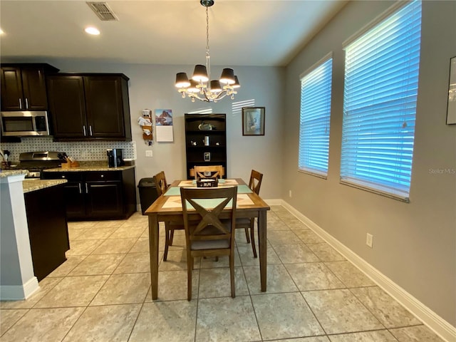 tiled dining room featuring a chandelier