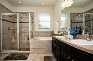 bathroom featuring tile patterned flooring, shower with separate bathtub, and vanity