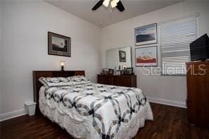 bedroom with ceiling fan and dark wood-type flooring