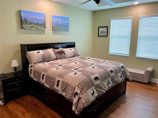 bedroom featuring multiple windows, hardwood / wood-style flooring, and ceiling fan