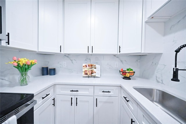 kitchen with white cabinets, sink, and backsplash