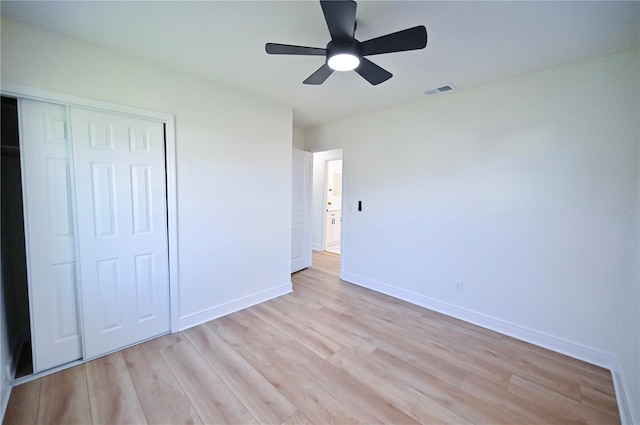 unfurnished bedroom featuring light hardwood / wood-style flooring, a closet, and ceiling fan