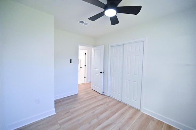 unfurnished bedroom featuring a closet, light hardwood / wood-style floors, and ceiling fan