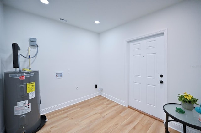 laundry area with hookup for a gas dryer, water heater, light hardwood / wood-style flooring, and hookup for a washing machine