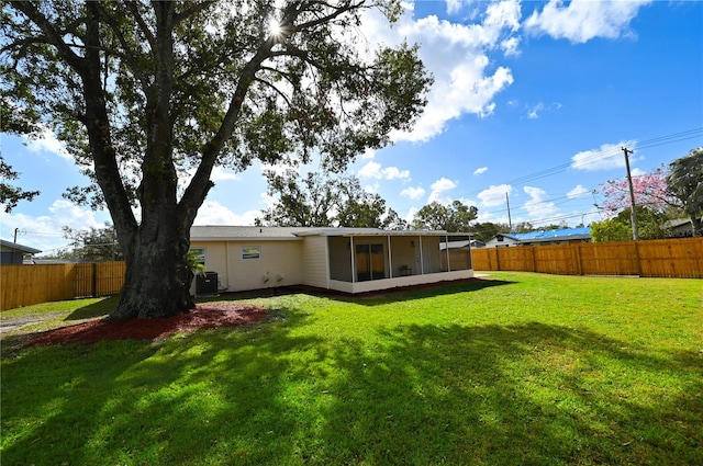 back of property with a yard and a sunroom