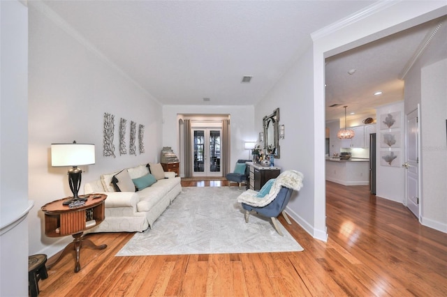 living room with hardwood / wood-style floors and crown molding