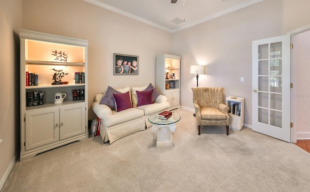 living room featuring light colored carpet, ceiling fan, and ornamental molding