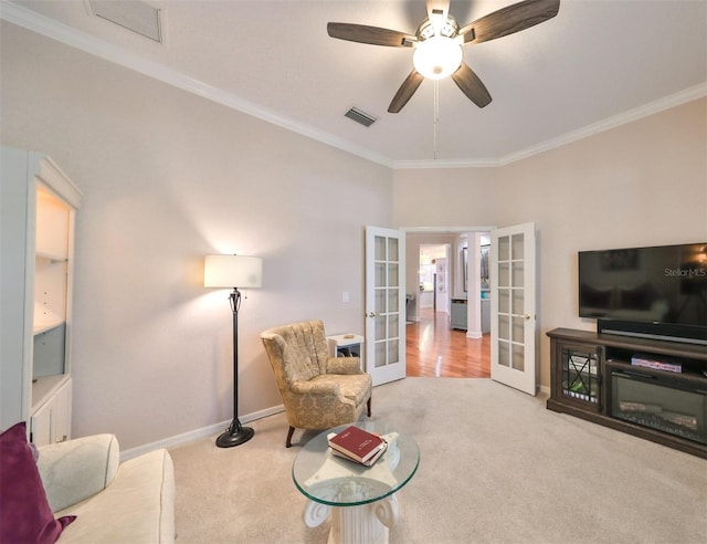 carpeted living room with ceiling fan, crown molding, and french doors