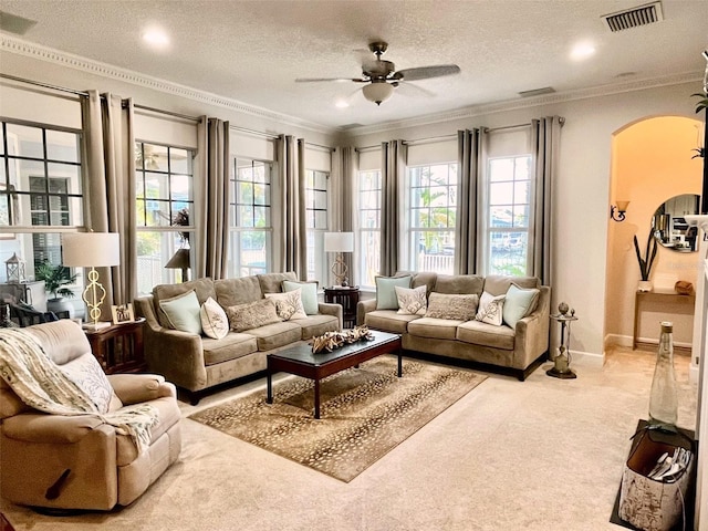 interior space with a textured ceiling, ceiling fan, and ornamental molding