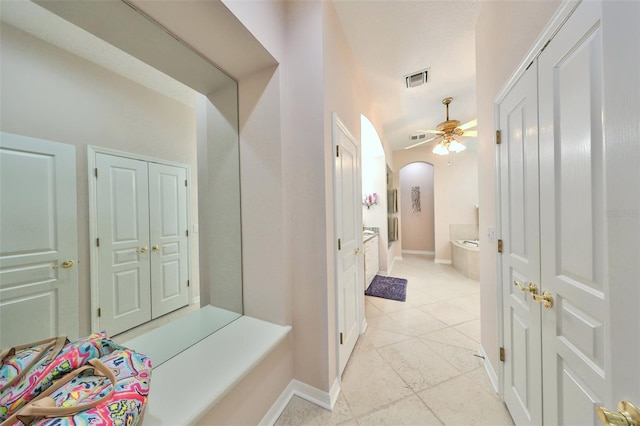 bathroom with ceiling fan and a tub to relax in