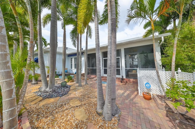 rear view of property featuring a patio area and a sunroom