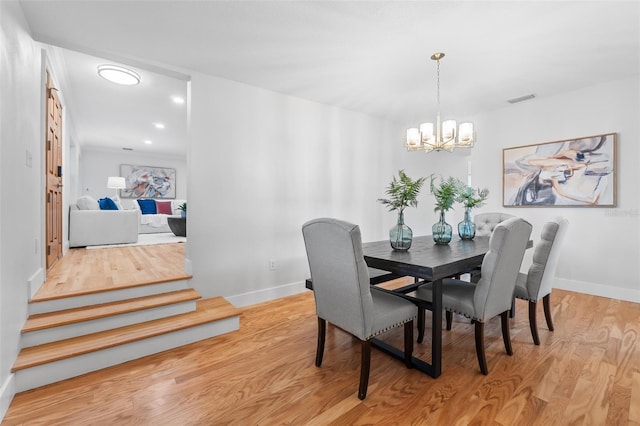 dining space featuring an inviting chandelier and light wood-type flooring