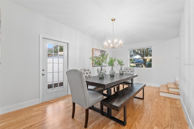 dining space featuring light hardwood / wood-style flooring and a chandelier