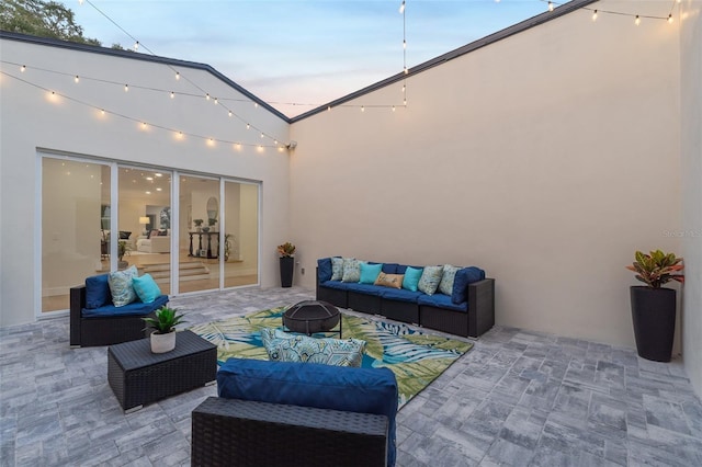 patio terrace at dusk featuring an outdoor living space with a fire pit