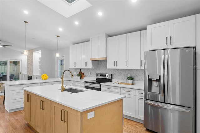 kitchen featuring white cabinets, sink, an island with sink, and appliances with stainless steel finishes