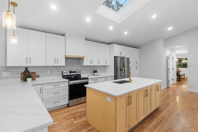 kitchen with pendant lighting, white cabinets, light stone countertops, an island with sink, and appliances with stainless steel finishes