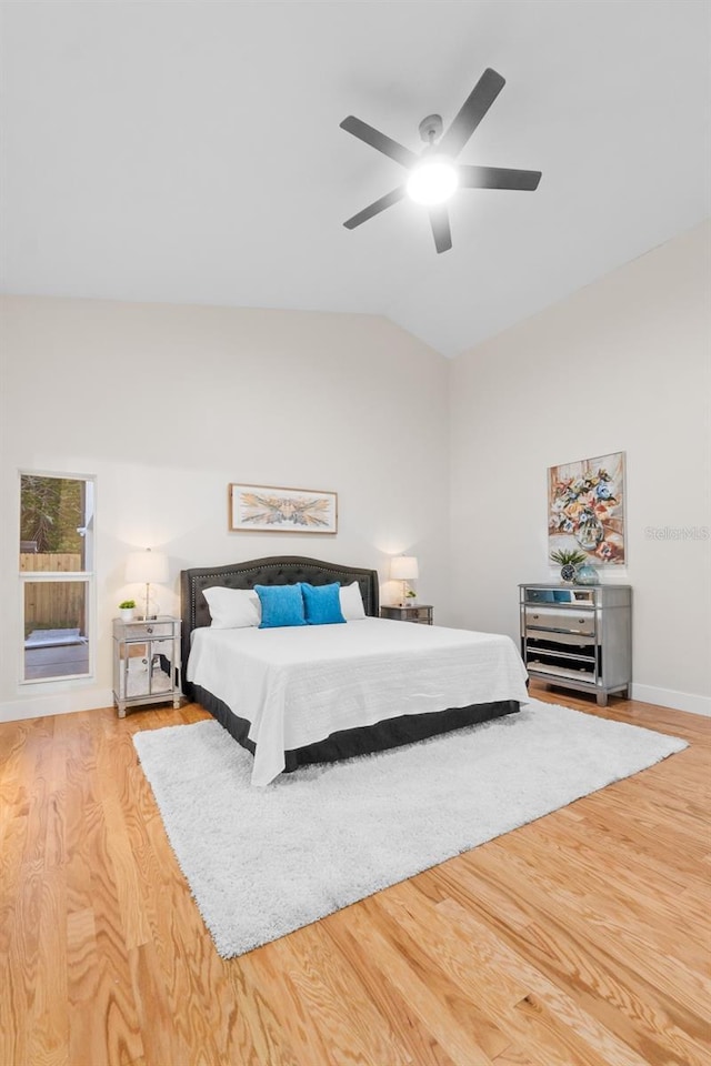 bedroom with ceiling fan, light hardwood / wood-style flooring, and lofted ceiling