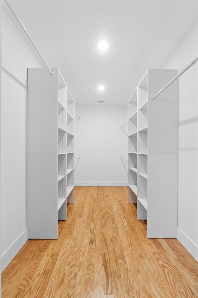 spacious closet with hardwood / wood-style flooring