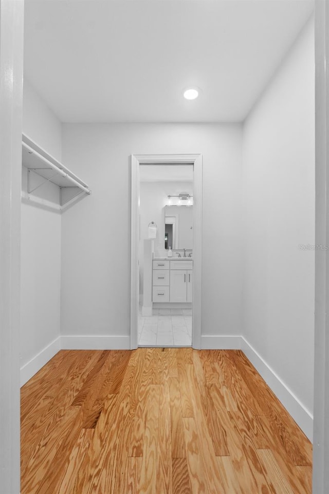 walk in closet featuring sink and light wood-type flooring