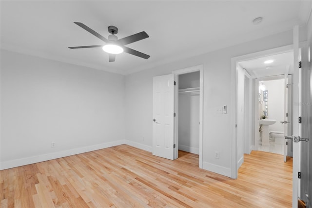 unfurnished bedroom with ceiling fan, light wood-type flooring, crown molding, and a closet