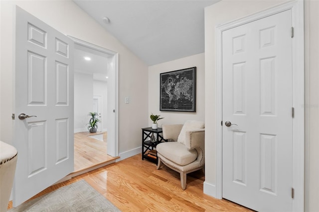 sitting room with lofted ceiling and wood-type flooring