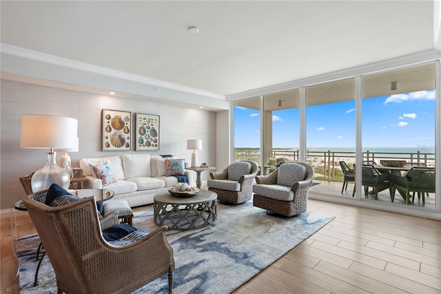 living room with a water view, light hardwood / wood-style floors, and floor to ceiling windows