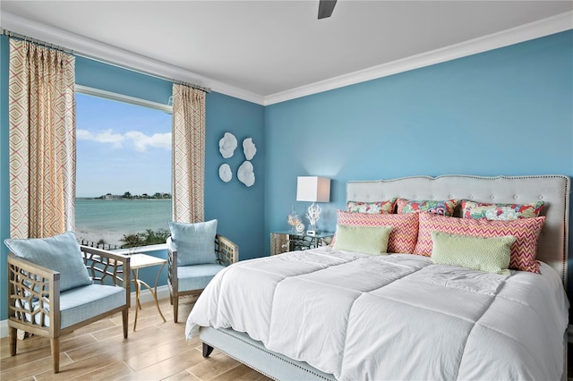 bedroom with ornamental molding, hardwood / wood-style floors, a water view, and ceiling fan