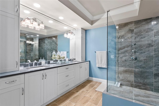 bathroom with vanity, an enclosed shower, a chandelier, and a raised ceiling