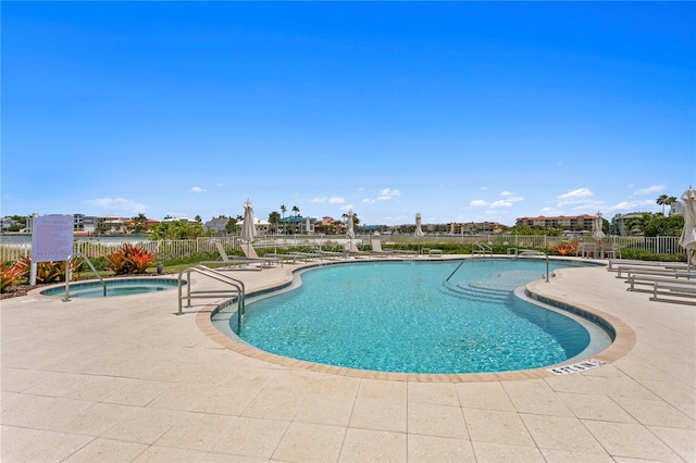 view of pool with a hot tub and a patio