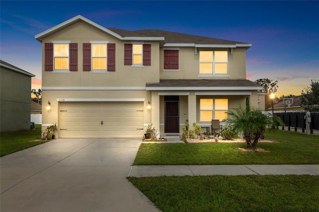 view of front of home with a yard and a garage