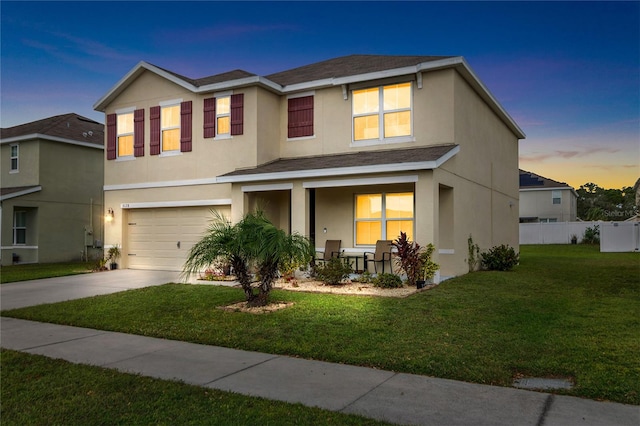 view of front of home with a garage and a lawn