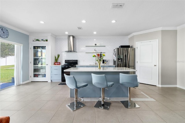 kitchen with a breakfast bar, electric range, wall chimney range hood, and stainless steel fridge with ice dispenser