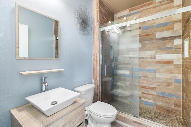 bathroom featuring toilet, an enclosed shower, and vanity