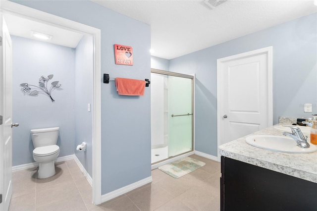 bathroom featuring vanity, tile patterned flooring, toilet, and walk in shower