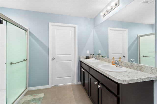 bathroom featuring a shower with door, vanity, a textured ceiling, and tile patterned flooring