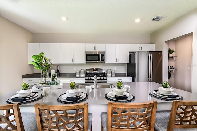 kitchen featuring appliances with stainless steel finishes, white cabinetry, sink, and a textured ceiling