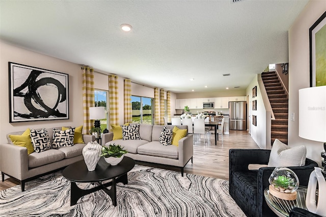 living room featuring light hardwood / wood-style floors and a textured ceiling