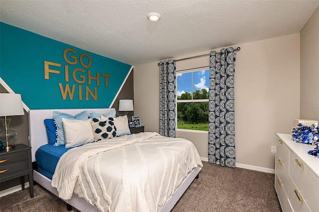 bedroom with dark colored carpet and a textured ceiling