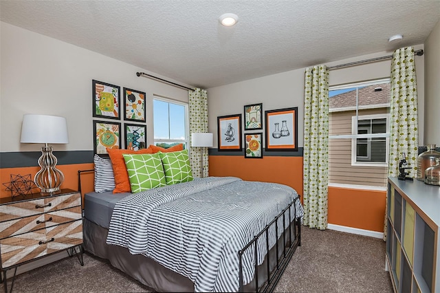 bedroom featuring dark colored carpet and a textured ceiling