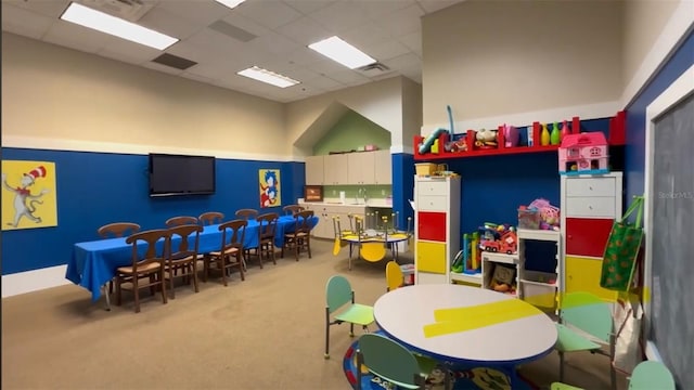 playroom featuring a paneled ceiling, carpet floors, and sink