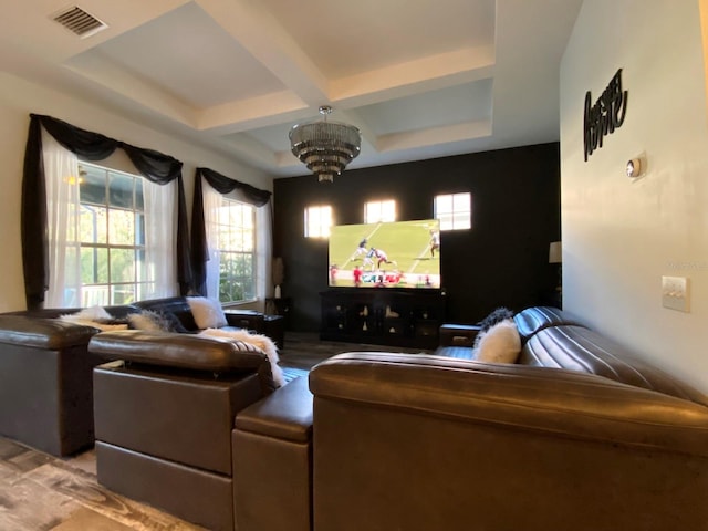 home theater room featuring a chandelier, beam ceiling, and coffered ceiling