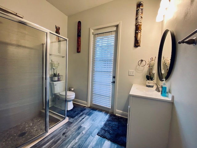 bathroom featuring hardwood / wood-style floors, vanity, toilet, and an enclosed shower