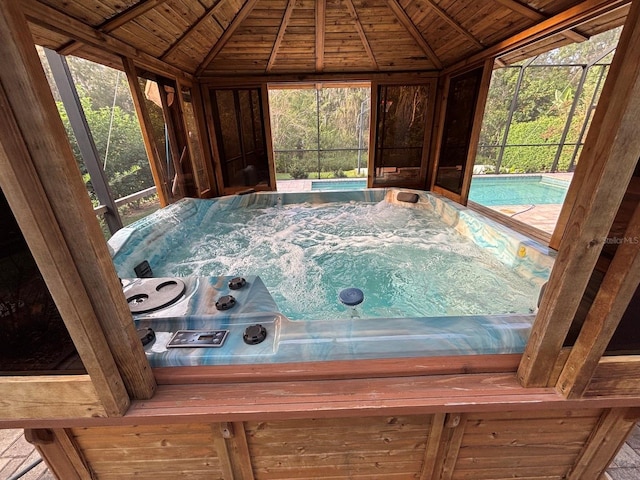 interior space with wooden ceiling, lofted ceiling, and a pool with hot tub