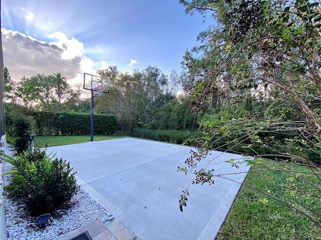 view of sport court with a lawn