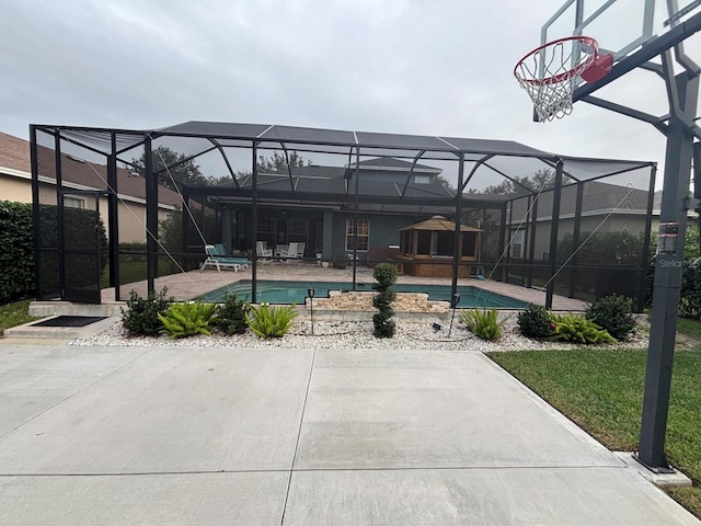 view of pool featuring glass enclosure and a patio area