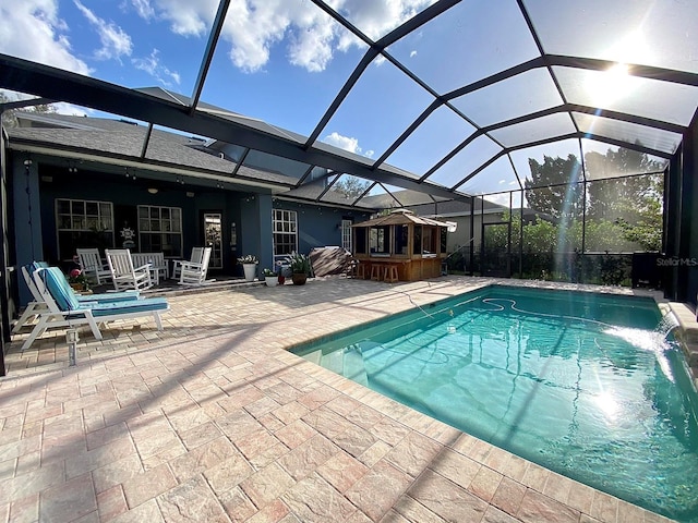 view of swimming pool featuring pool water feature, a patio area, and a lanai