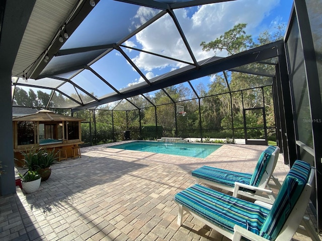 view of pool featuring pool water feature, a patio, and glass enclosure