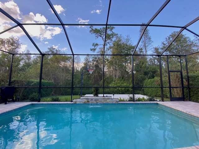 view of swimming pool with pool water feature and a lanai